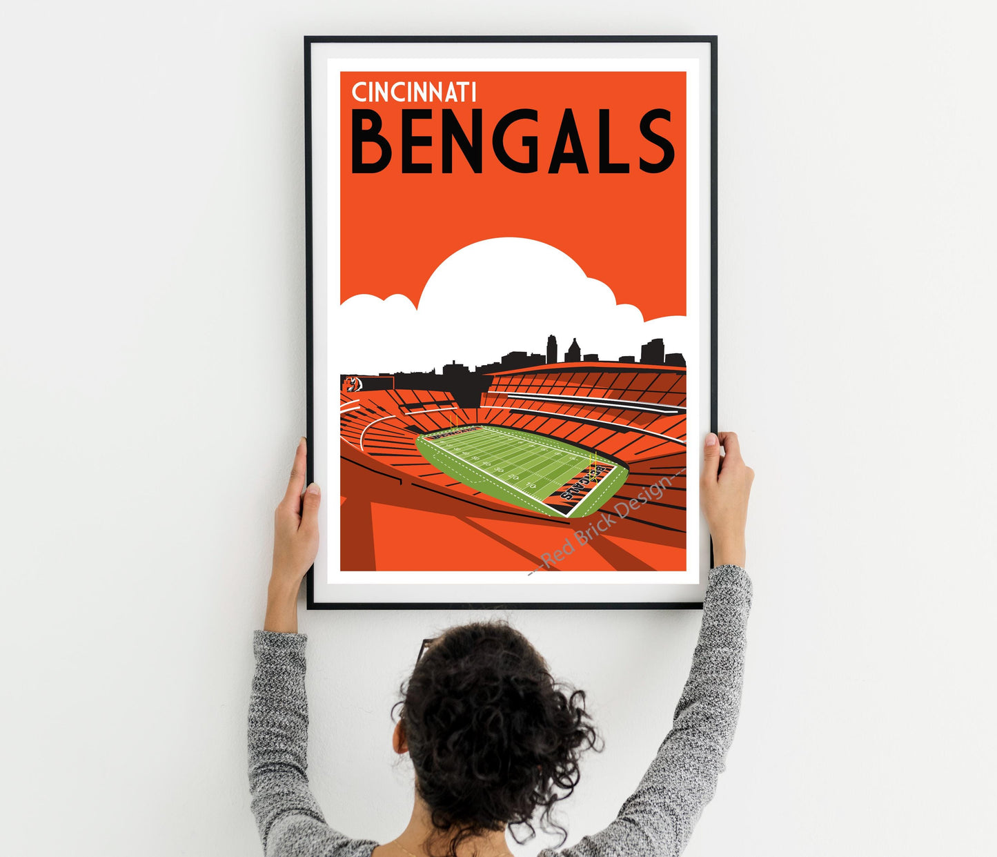 a woman holding up a poster of a stadium
