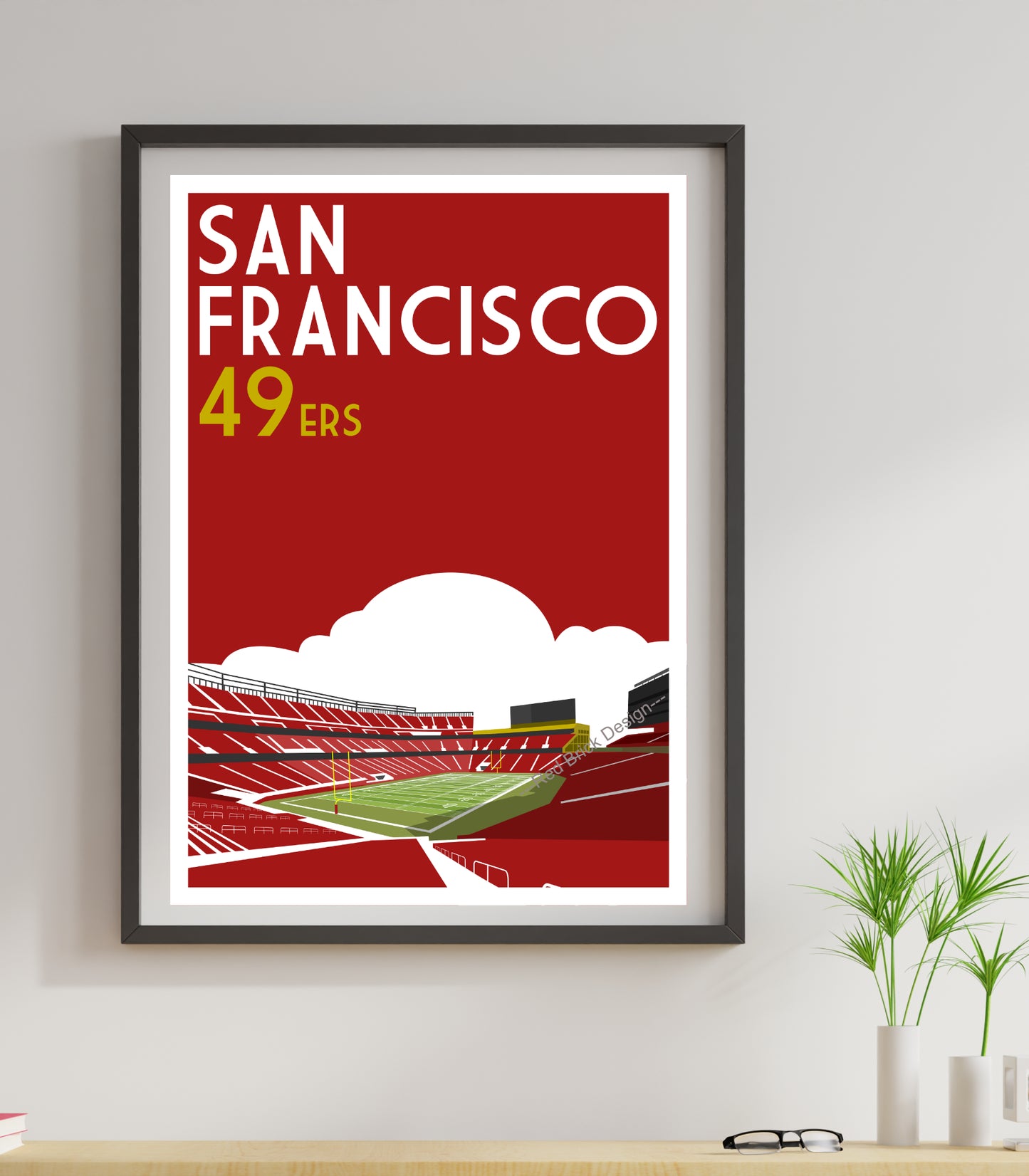 a framed poster of a stadium with a red background
