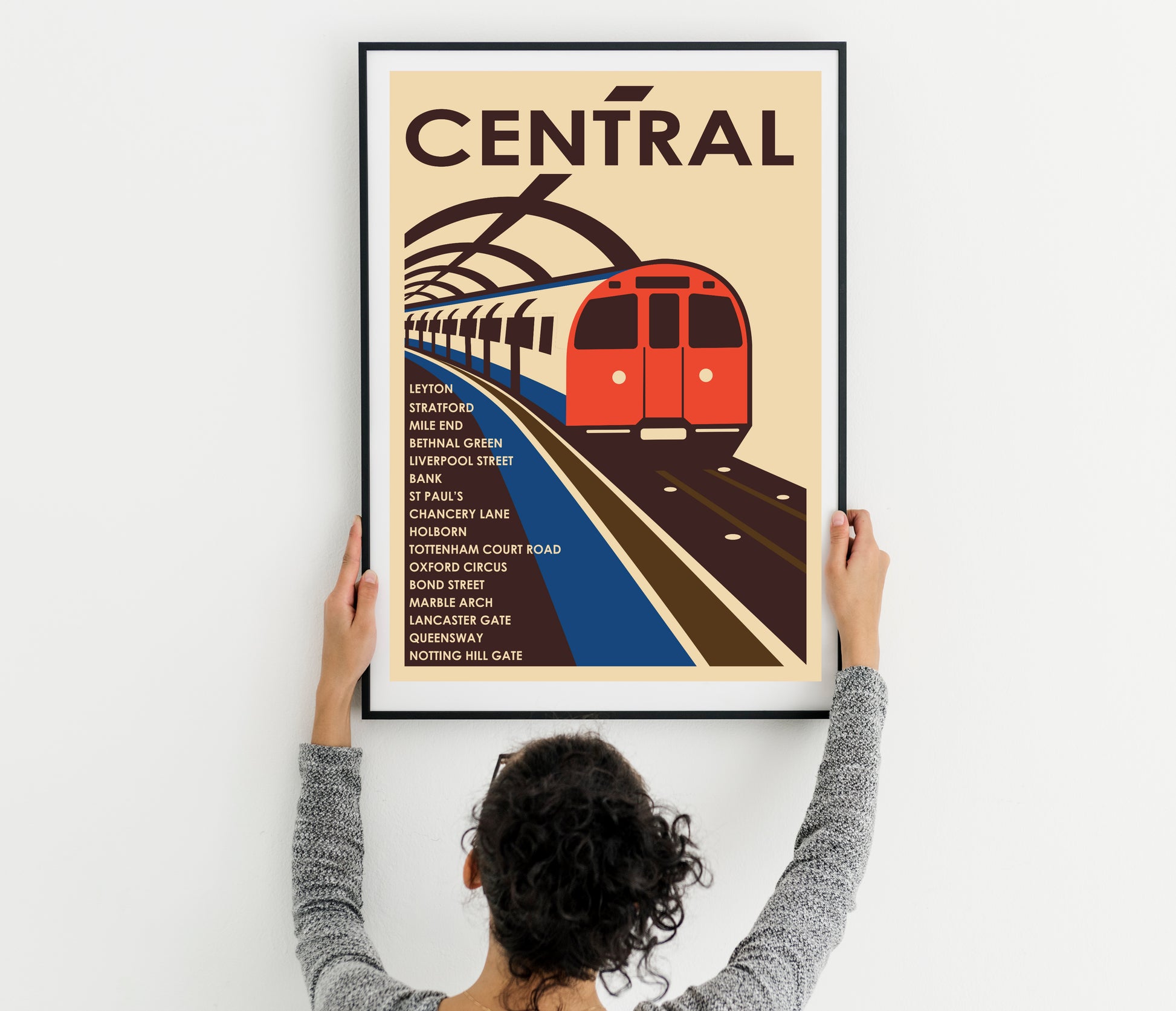Retro-style Central Line central section poster design, a picture of a train on a train track, a woman holding up a poster with a train on it