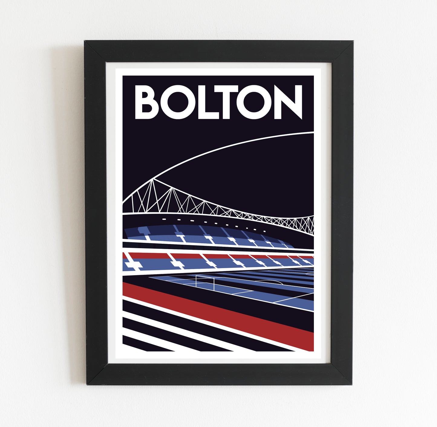 A framed poster depicting a stadium with a bridge in the background.