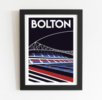 A framed poster depicting a stadium with a bridge in the background.
