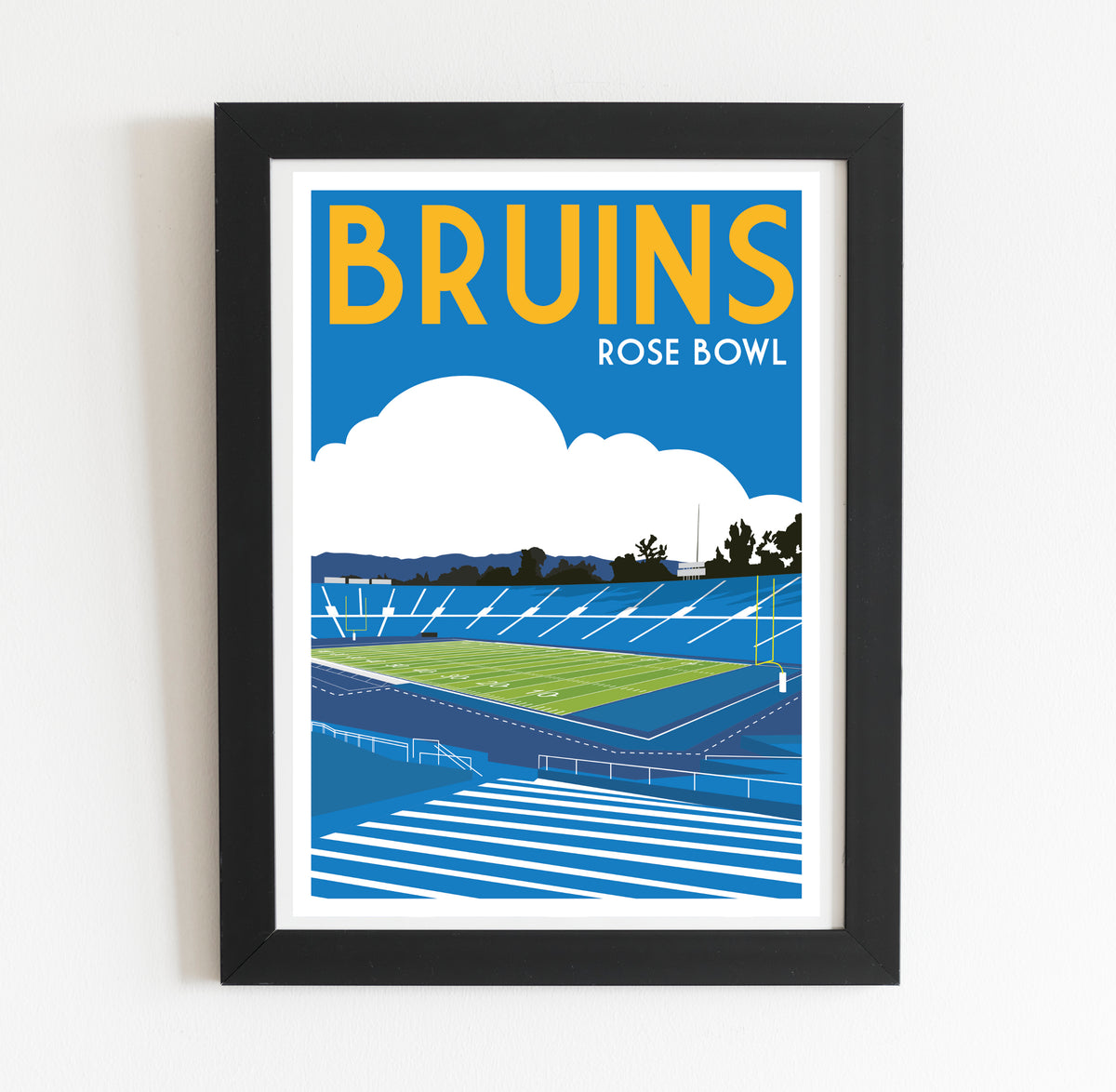The image is a framed poster depicting a sports stadium, specifically the Bruins Rose Bowl, with a cloudy sky in the background.