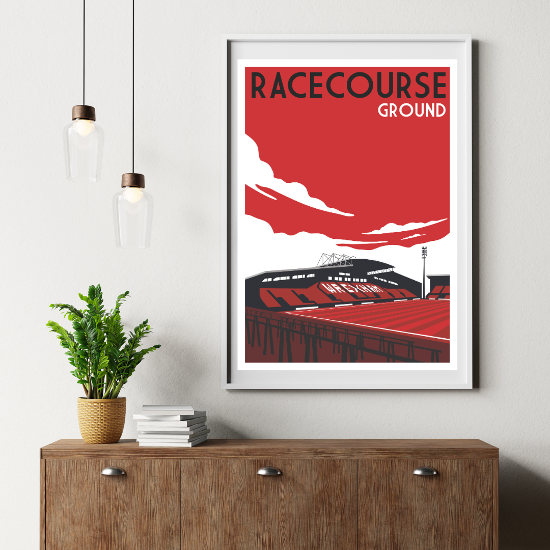 a framed poster of a stadium with the text "RACECOURSE GROUND" on it, hanging on a wall above a wooden dresser.