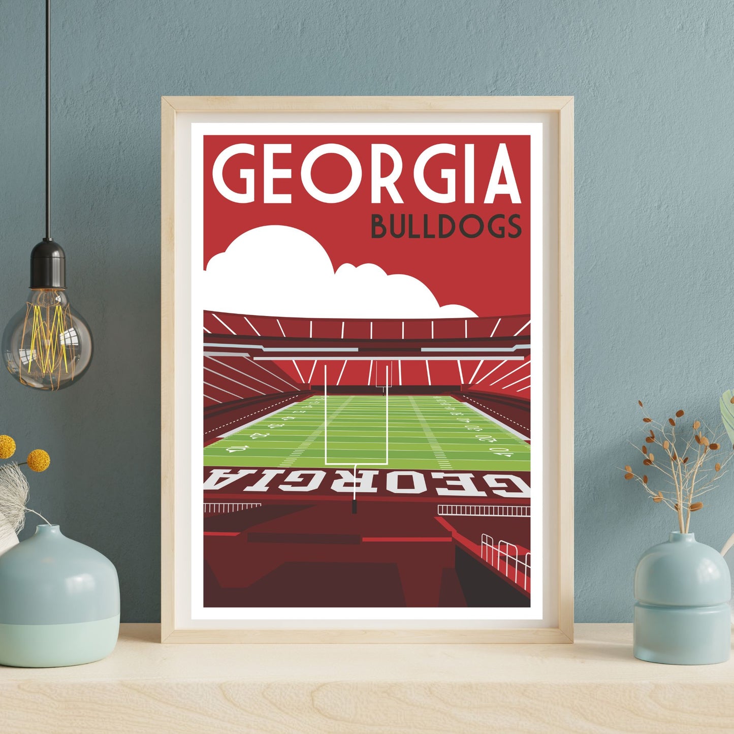 A framed poster depicting a football stadium with the text "GEORGIA BULLDOGS" prominently displayed.