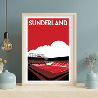A framed poster depicting a stadium with a red field and white seating, with the text "SUNDERLAND" prominently displayed.