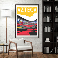 a framed poster of a stadium with the word "AZTECA" prominently displayed, hanging on a white brick wall in a room with a bookshelf and a white chair.