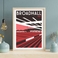 a framed poster of a sports stadium, specifically Broadhall Way, with a red and black color scheme.