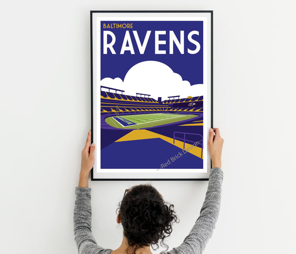 a woman holding up a framed poster of a stadium