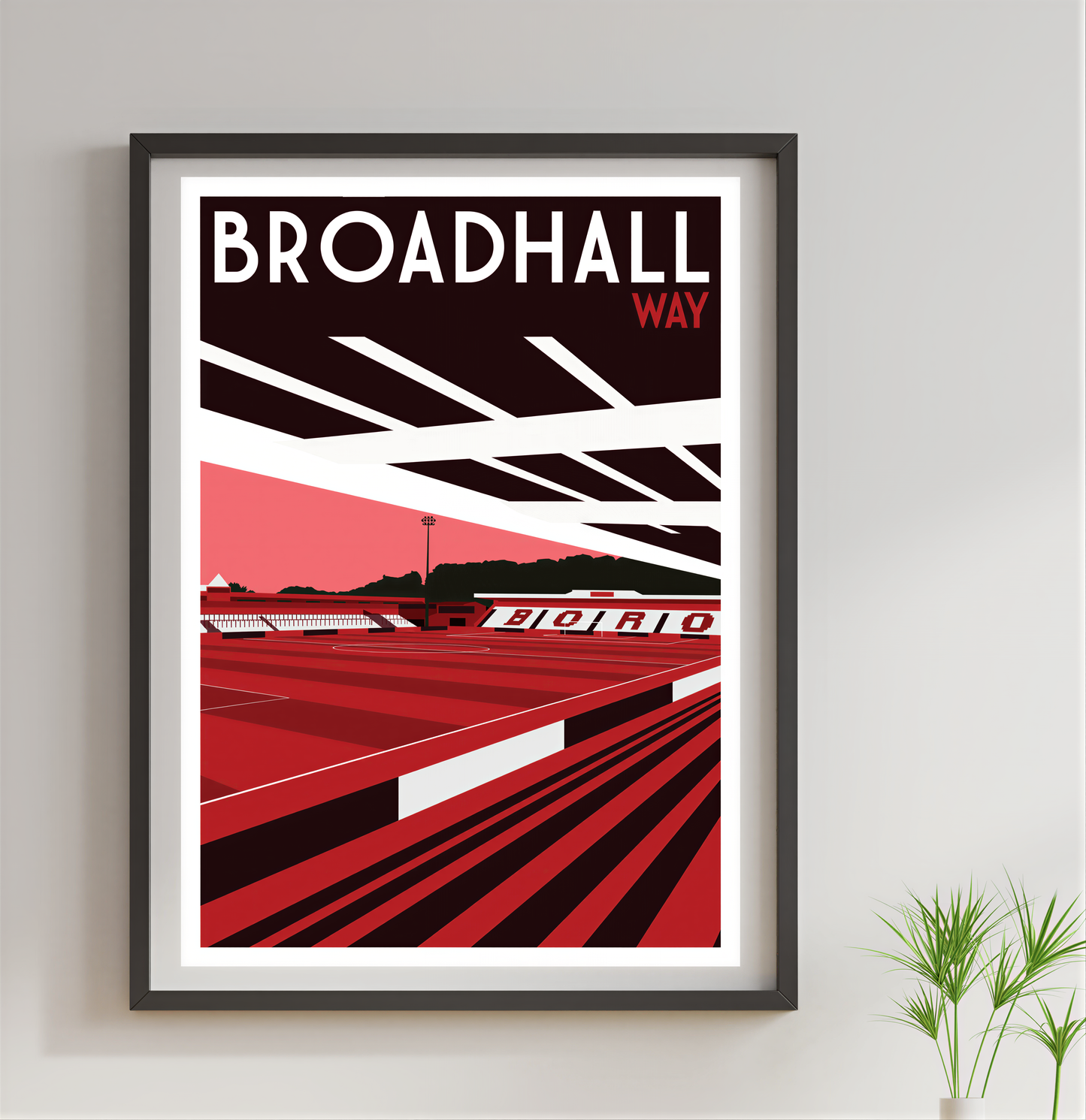 The image is a framed poster of Broadhall Way, a sports stadium in the UK. The poster features a red and black color scheme with a geometric design, depicting the stadium and its surroundings.