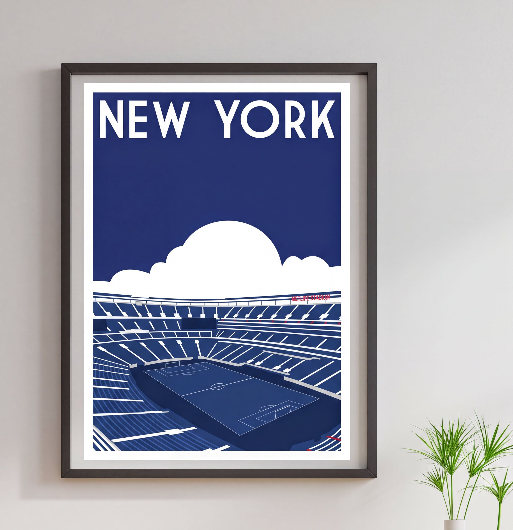 A framed poster depicting a soccer stadium with a cloudy sky in the background.