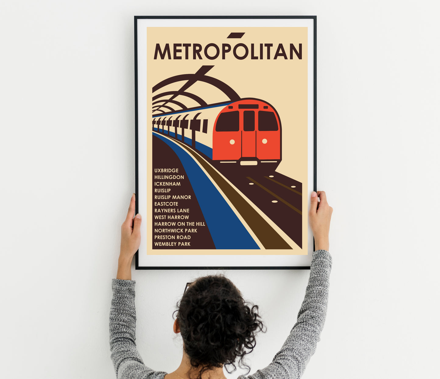 London tube train a picture of a train on a train track and a woman holding up a poster with a train on it