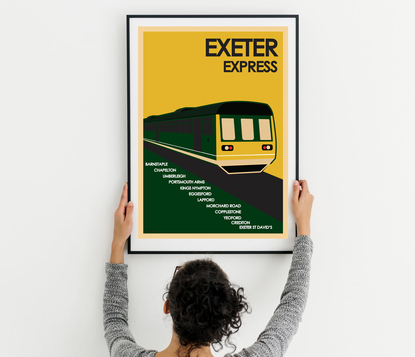 Vintage Rail Travel Poster: Exeter Express, Devon - Art Print Poster and a woman holding up a poster with a train on it