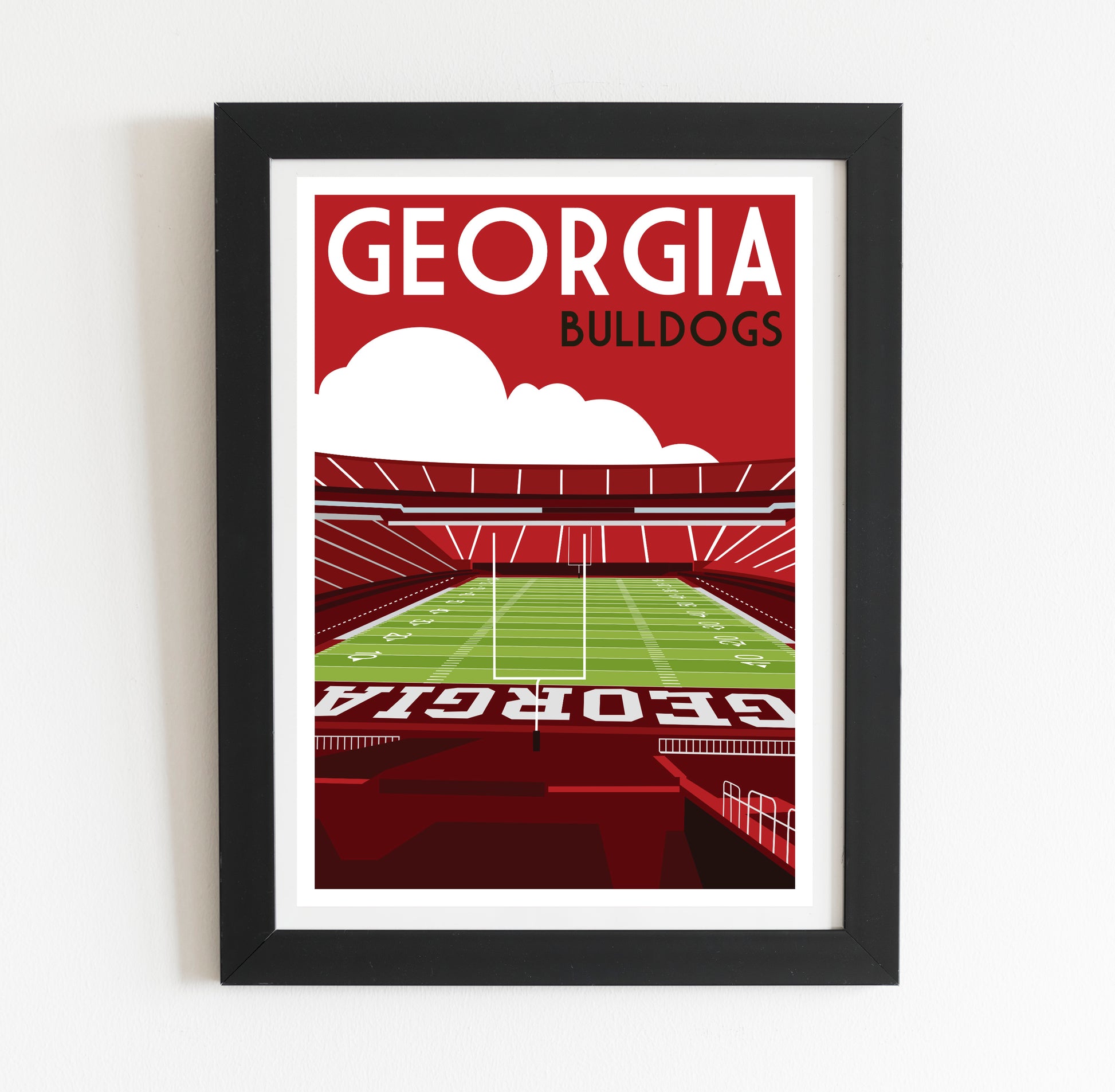 A framed poster depicting a football stadium with the text "GEORGIA BULLDOGS" prominently displayed.