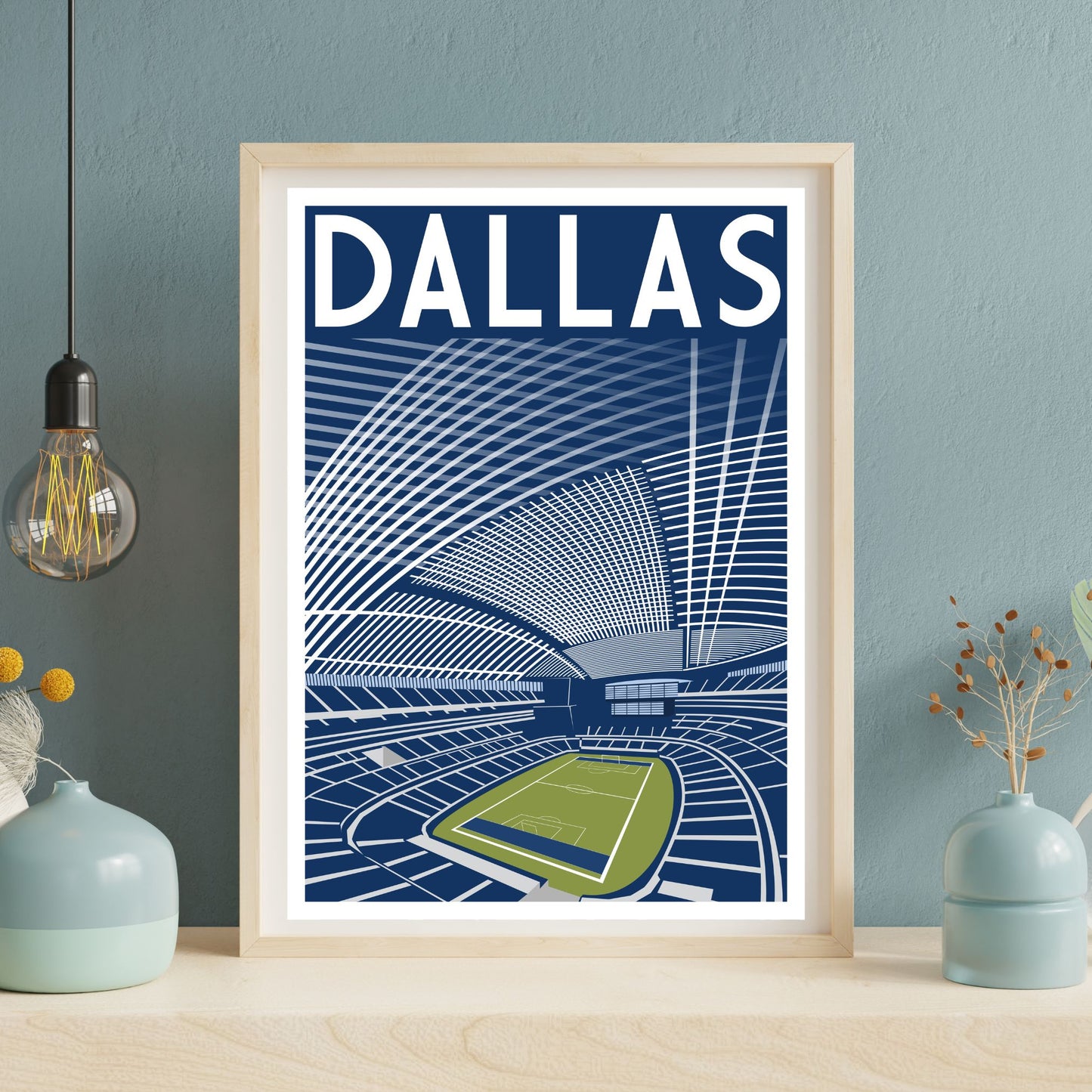 A framed poster of a stadium with a large stadium seating area and a large field, with the word "DALLAS" prominently displayed.