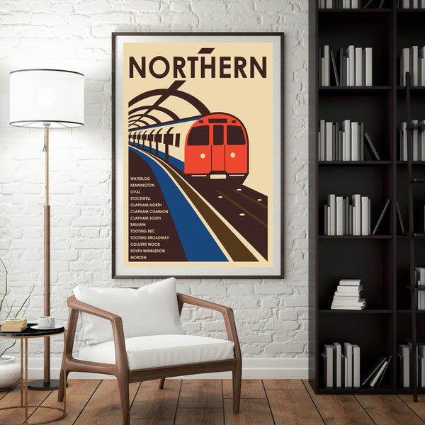 a poster of a red train on a track, hanging on a white brick wall in a room with a bookshelf and a chair.
