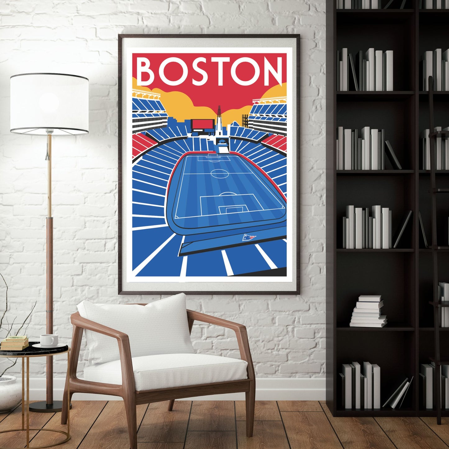 a framed poster of a soccer stadium in Boston, with a white chair in the foreground and a bookshelf filled with books in the background.
