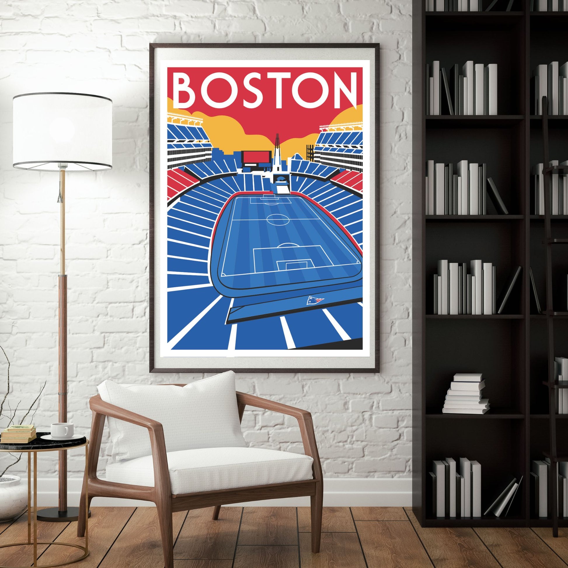 a framed poster of a soccer stadium in Boston, with a white chair in the foreground and a bookshelf filled with books in the background.