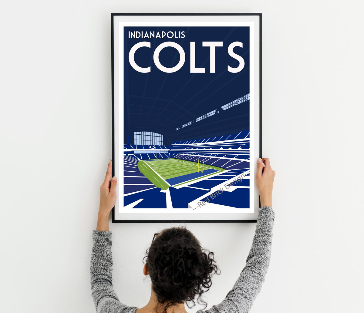 a woman holding up a framed poster of a tennis court