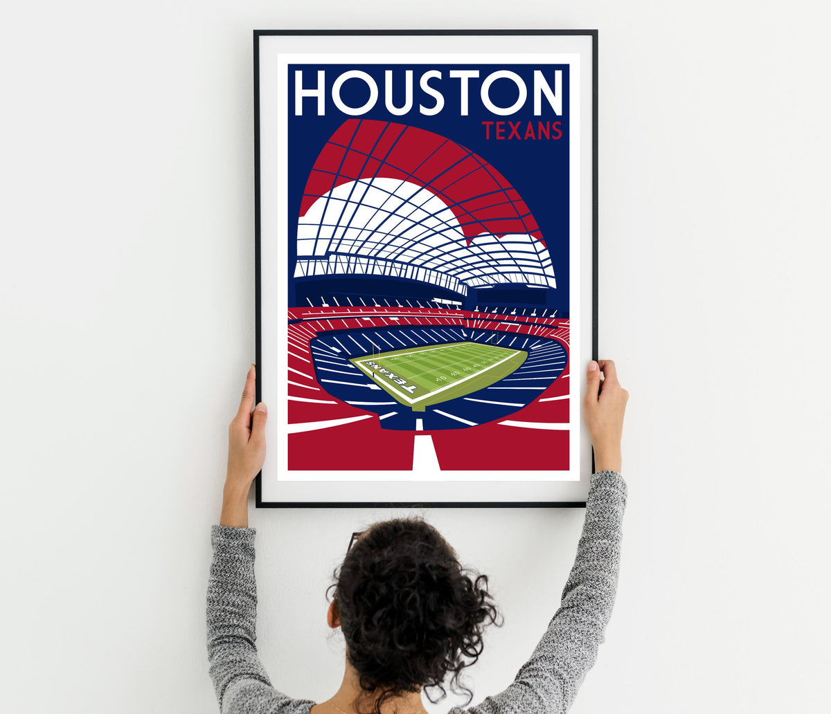 a woman holding up a poster of a stadium